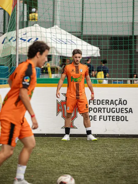 Jogadores de equipamento laranja durante o jogo no Nacional de Futebol de Rua de Viseu 2026.