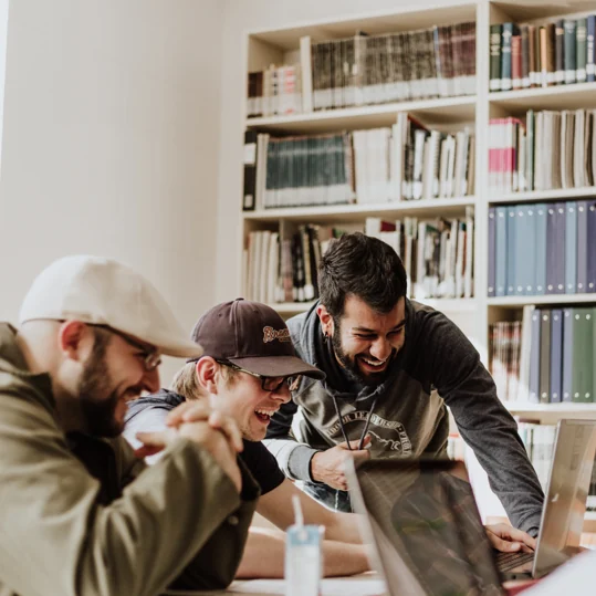 Jovens a aprender em conjunto, à volta de um computador.